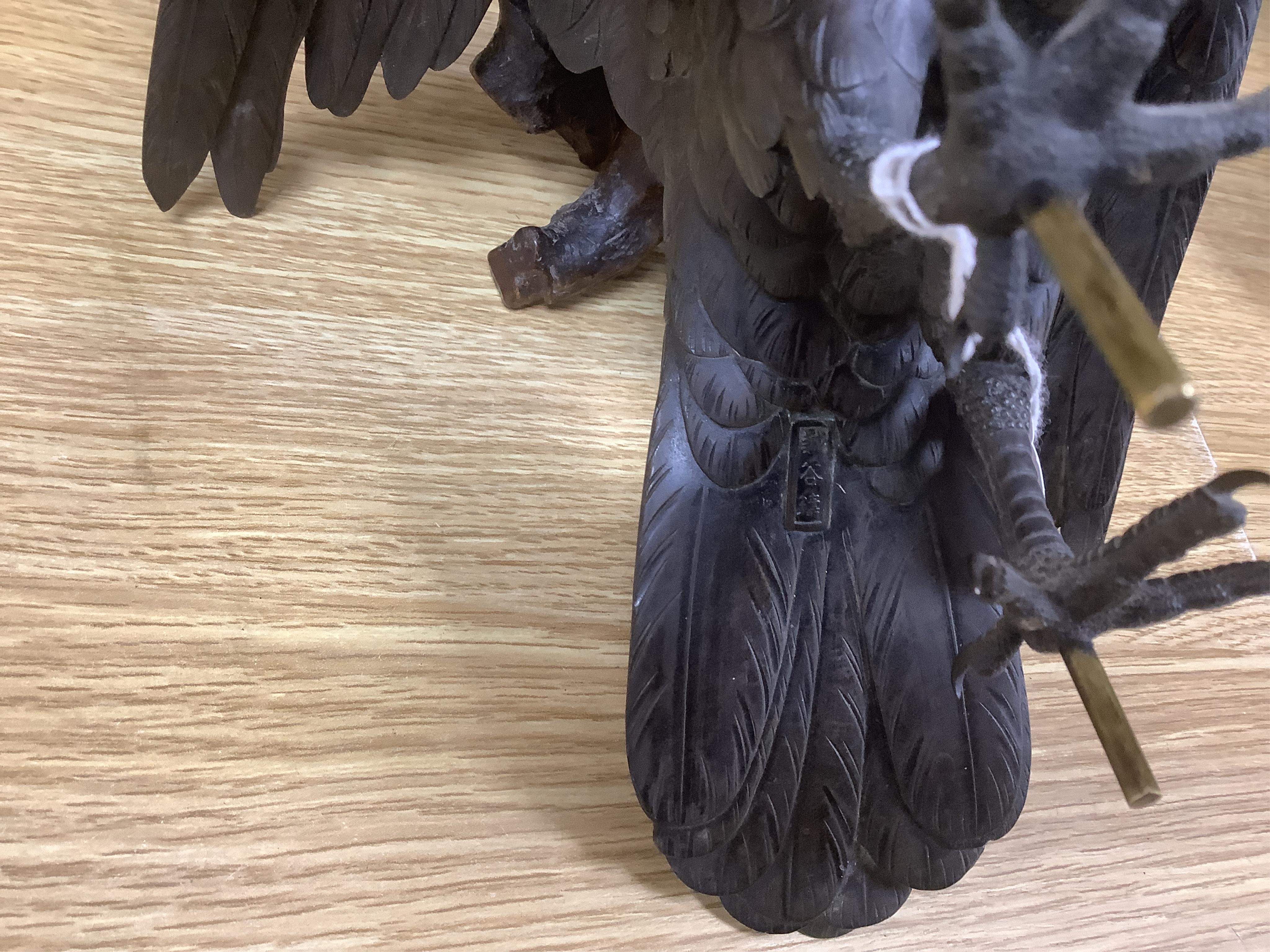 A Japanese Meiji period cast bronze model of a hawk, raised on a naturalistic carved root wood base, signed to tail underside, 39.5cm. Condition - good